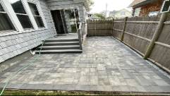 effective wall installation, meticulous crew, photorealistic, arid environment with minimal vegetation, highly detailed, concrete blocks and wheelbarrows, shot with a 35mm lens, brown and tan colors, harsh sunlight